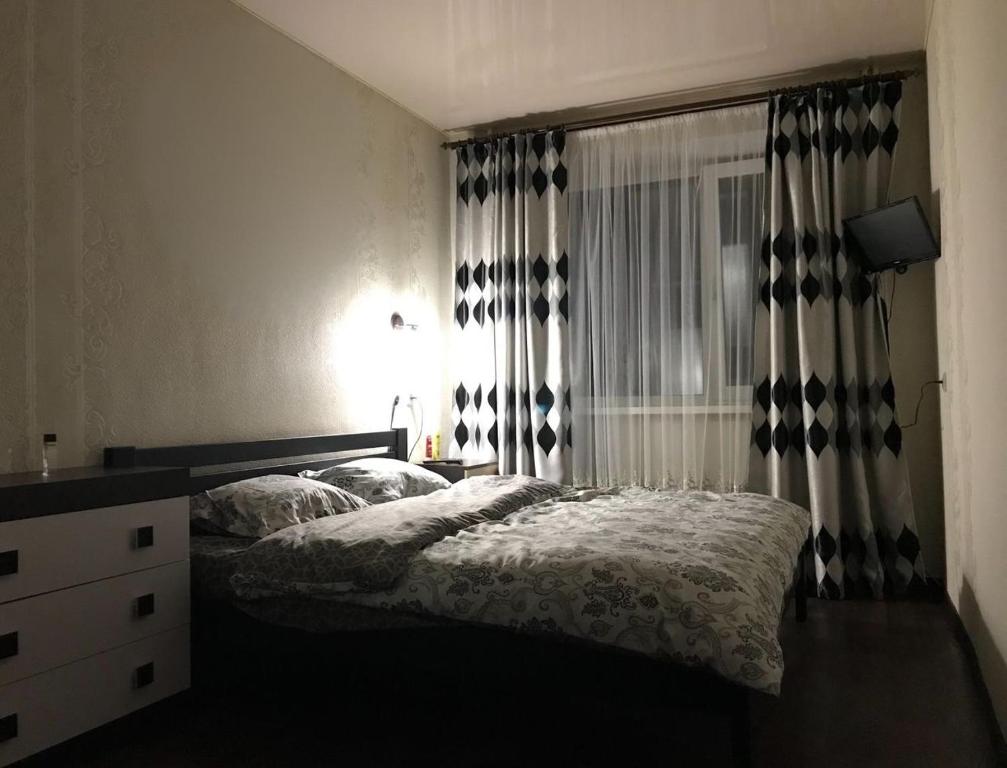 a bedroom with a bed and a dresser and a window at чудова охайна квартира in Sumy