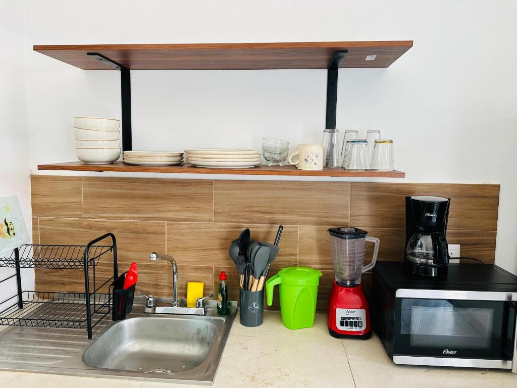 a kitchen counter with a sink and a microwave at Casa Diamante Style, Peace & Prime Location in Manzanillo