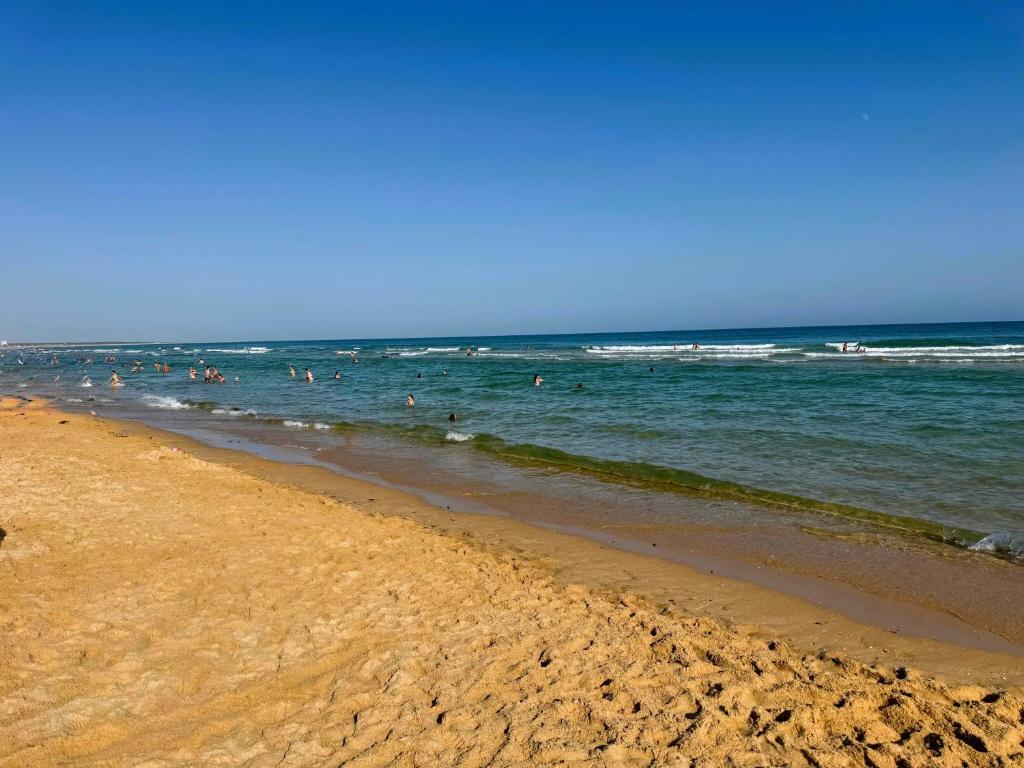 a group of people in the water at the beach at Mimosa House Cabanas in Cabanas de Tavira