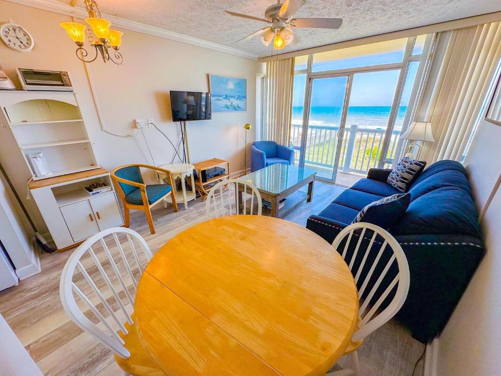 a living room with a table and a blue couch at Grand Strand Resort II 18 in North Myrtle Beach