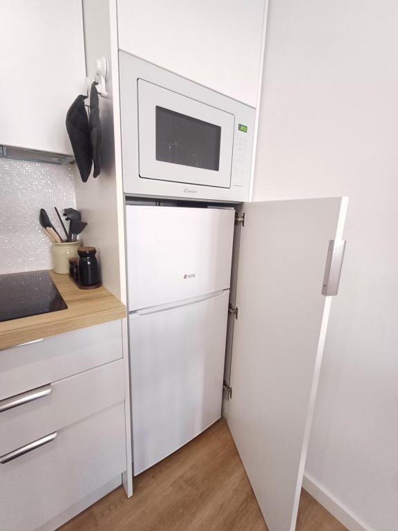 eine Küche mit einer Mikrowelle auf dem Kühlschrank in der Unterkunft Villa Rica in Azeitão