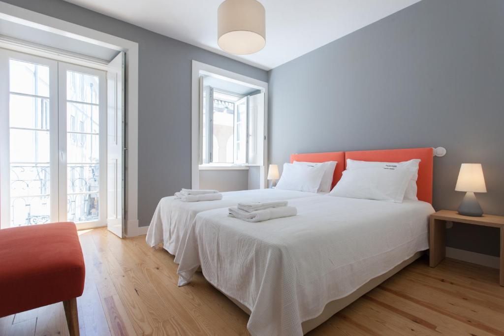 - une chambre avec un grand lit blanc et une tête de lit rouge dans l'établissement FLH Principe Real Luxus Apartments, à Lisbonne