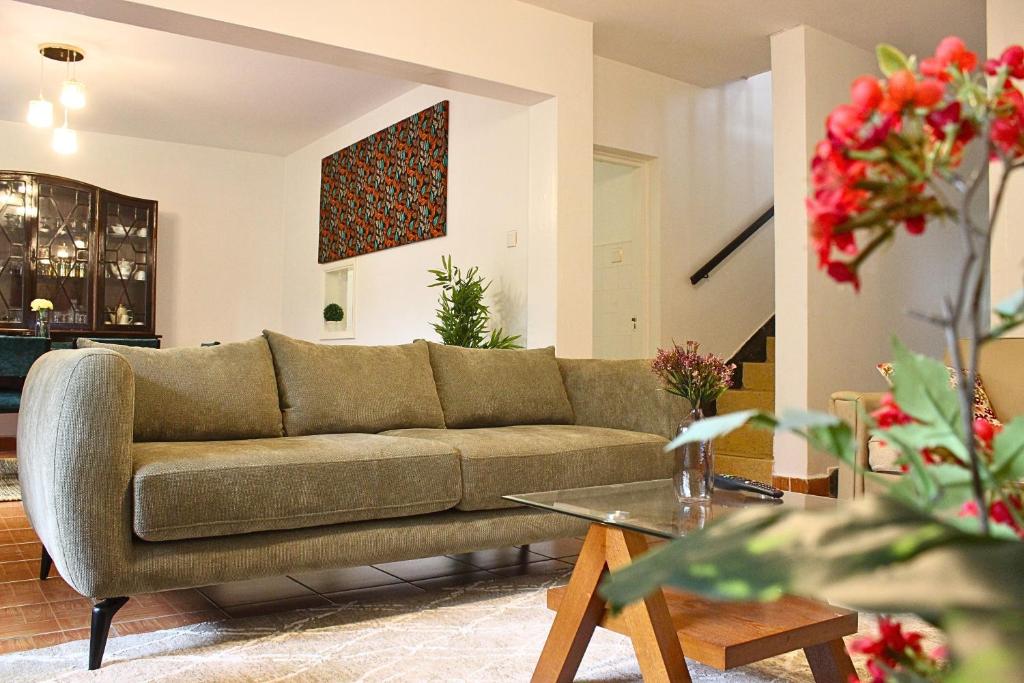 a living room with a couch and a table at Charming 3-Bedroom Townhouse with Garden & Balcony - Lavington, Nairobi in Nairobi