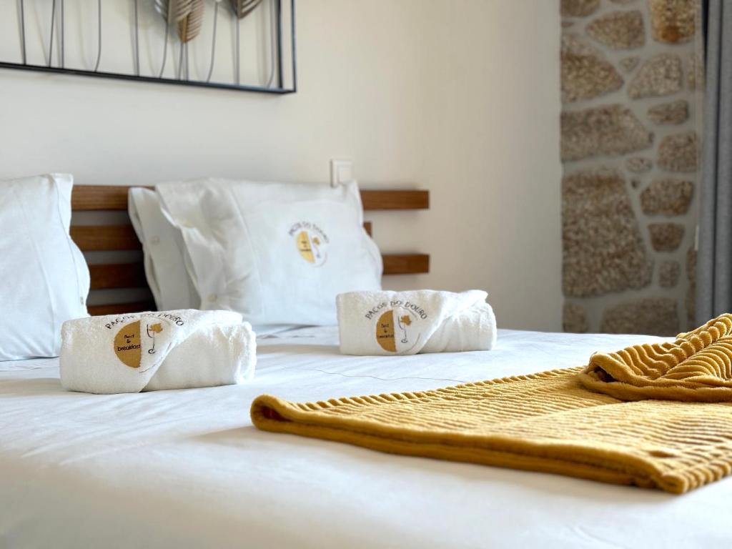 a white bed with towels on top of it at Paços de Douro - Chambre 1 Jardin & Lumière in Romariz