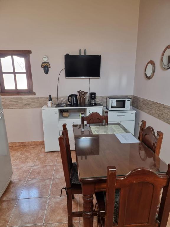 a kitchen with a dining room table and a television at KAKAN cómodo apartamento 1 dormitorio in Cafayate