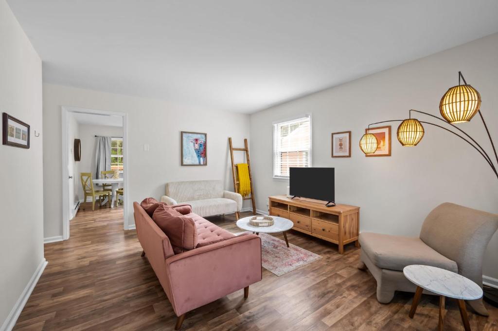 a living room with a couch and a tv at Bull City Bungalow Walk to Ninth St Near Duke in Durham
