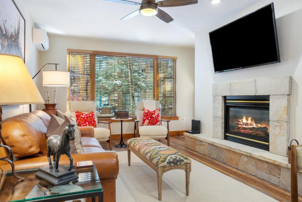Una sala de estar con chimenea y TV de pantalla plana. en 106 Pinecone Lodge, en Edwards