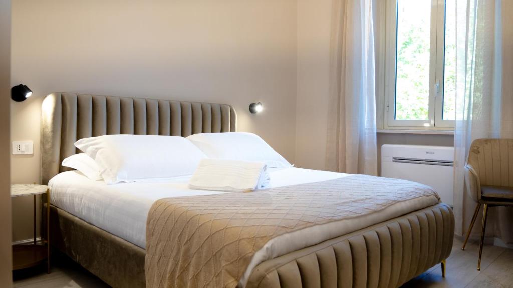 a bedroom with a large bed with white sheets and a window at Suites 215 Colosseum - Guesthouse in Rome