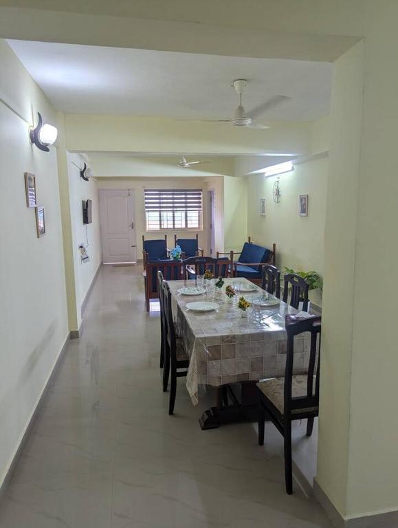 a dining room with a long table and chairs at Ocean Park Haven Apartments in Kannur