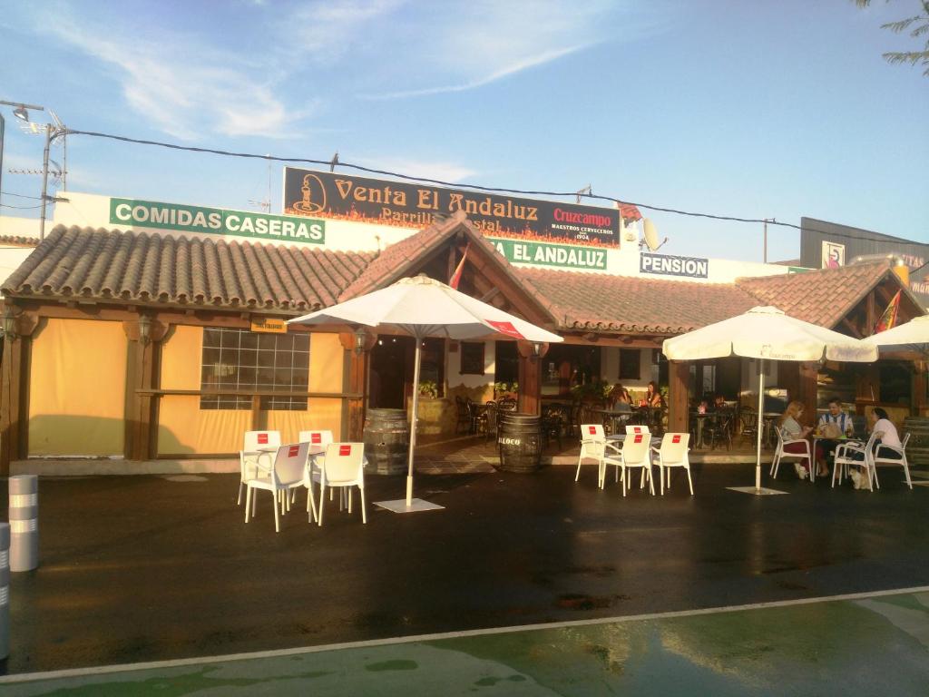 un groupe de chaises et de parasols devant un bâtiment dans l'établissement Parrilla Venta el Andaluz, à Conil de la Frontera