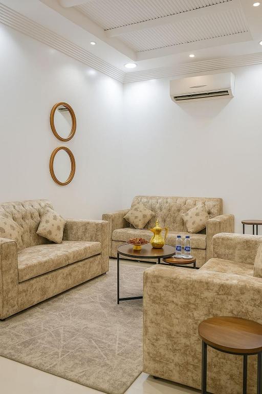 a living room with two couches and a table at شقق جنان المخدومة Jenaan Apartments in Najran