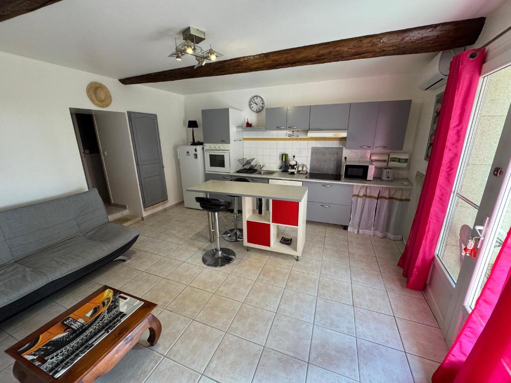 eine Küche mit einer Couch und einem Tisch in einem Zimmer in der Unterkunft Maison de charme, pleine nature in Saint-Côme-et-Maruéjols