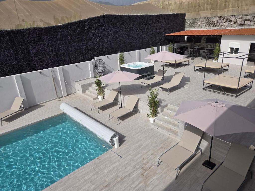 an overhead view of a swimming pool with chairs and umbrellas at Lagoon Suits in San Borondón