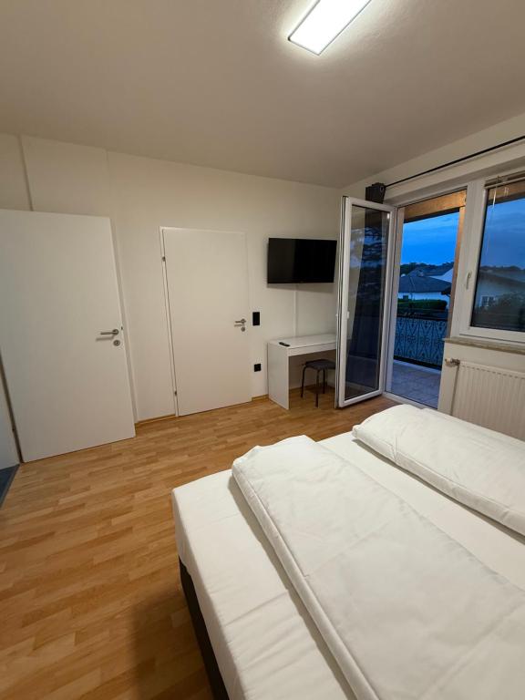 una camera da letto con un letto e una grande finestra di Airport Apartment Rauchenwarth a Rauchenwarth