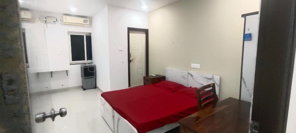a small room with a red bed in it at Vaarahi Enclave Kondapur in Hyderabad