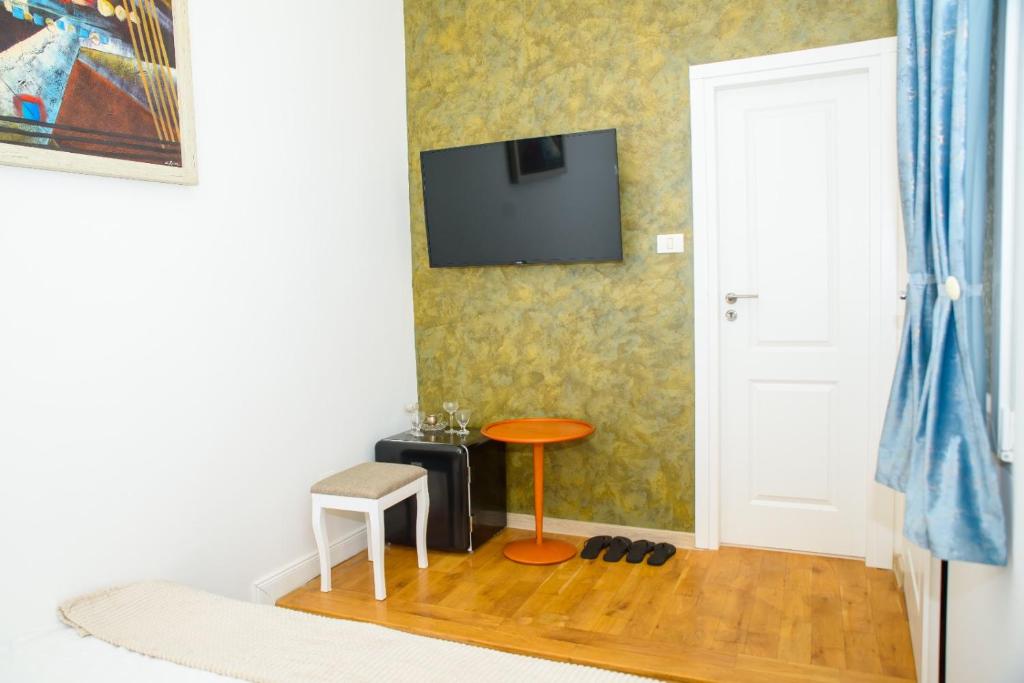 a room with a tv on the wall and a stool at Bistro Centru Vechi Craiova in Craiova