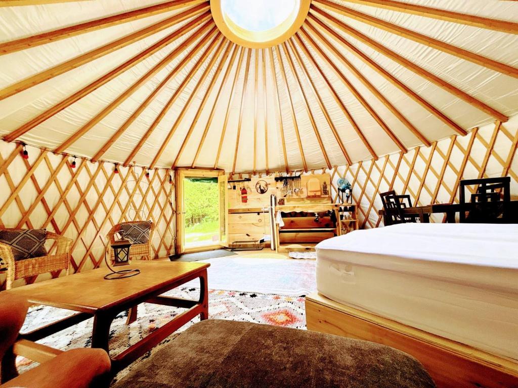 a room with a bed and a table in a yurt at Sky Nest Glamp-Unplug-Reconnect in Red Bay