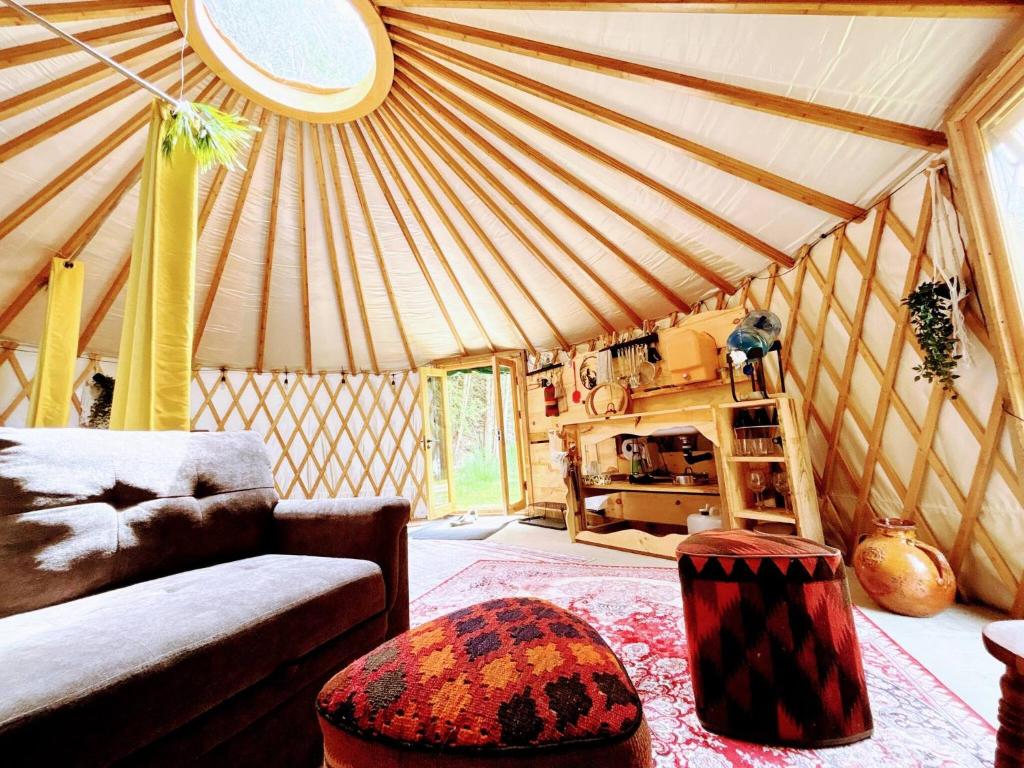 a living room with a couch and a bed in a yurt at Star-Lake Yurt Sanctuary Waterview in Red Bay