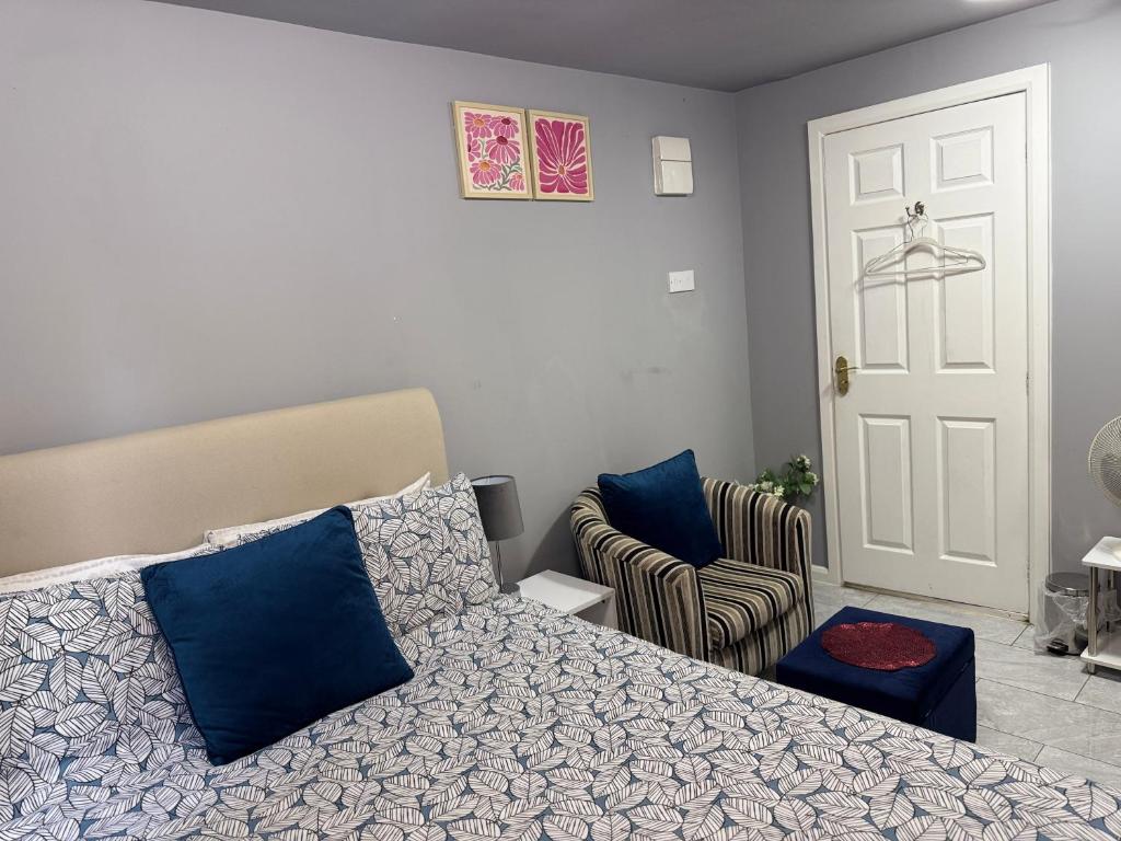 a bedroom with a bed and a chair and a door at Modern Studio Appartment in Cheltenham