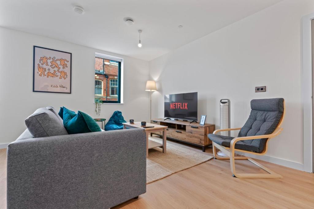a living room with a couch and a chair and a tv at 2 Bed Modern Apartment in City Centre Birmingham in Birmingham