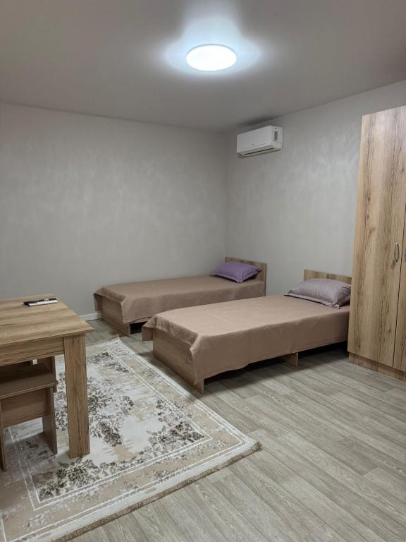 ein Zimmer mit zwei Betten und einem Tisch darin in der Unterkunft Фучика 50 in Zhezdi