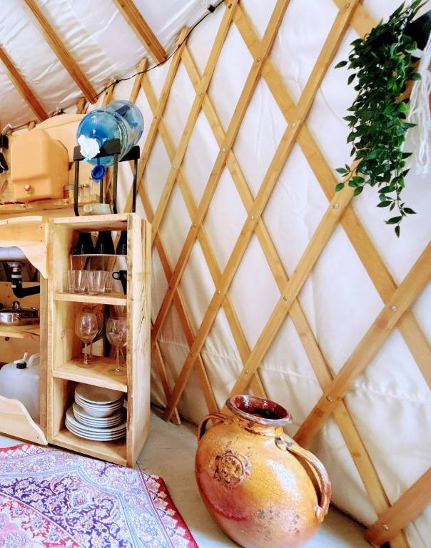 a room with a wooden wall and a table with a vase at Dreaming SkyLake Yurt Waterfront in Red Bay