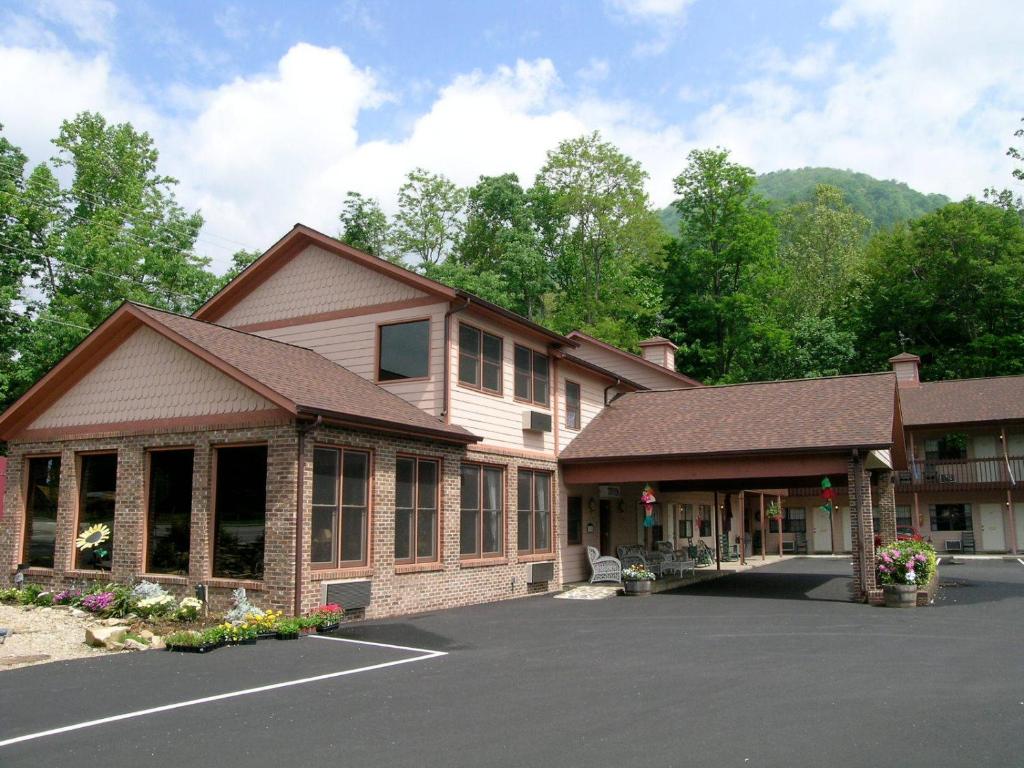 een gebouw met een parkeerplaats ervoor bij Jonathan Creek Inn and Villas in Maggie Valley