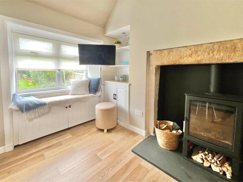 a living room with a fireplace and a window at Seatown Cottage - Stone's throw from beach in Lossiemouth