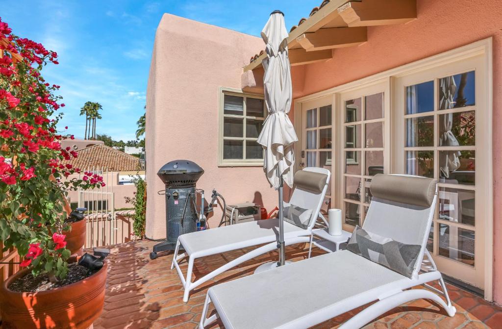 eine Terrasse mit zwei Stühlen und einem Sonnenschirm in der Unterkunft Chic Downtown Bungalow in Palm Springs