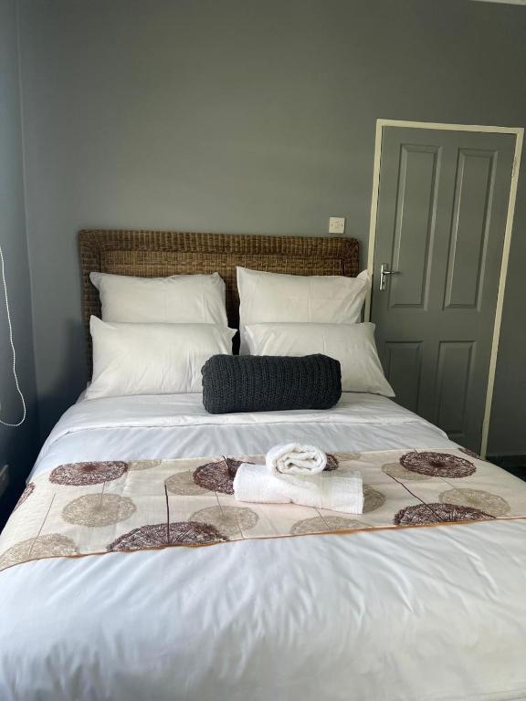 a bed with a black and white blanket on it at Inala Urban Guesthouse in Bulawayo