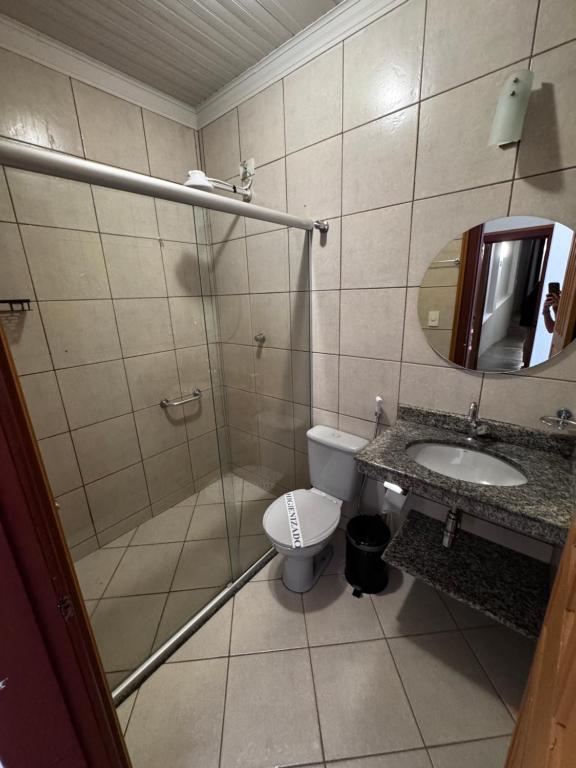 un bagno con doccia, WC e lavandino di Pousada Casa de Vó a Diamantina