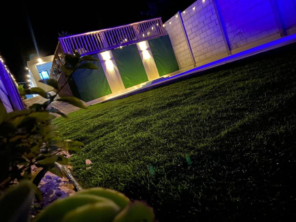 a building with blue lights on the grass at night at La Casa Bella De Lunahuana in Lunahuaná