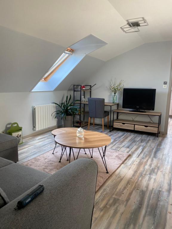a living room with a table and a tv at Appartement centre ville in Ussel