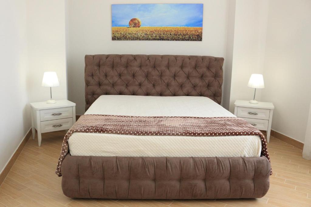 Un dormitorio con una cama grande con dos mesitas de noche. en Sul Teatro, en Matera