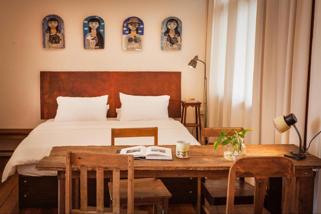 ein Schlafzimmer mit einem Bett, einem Holztisch und Stühlen in der Unterkunft Mana Craft Stay in Bangkok