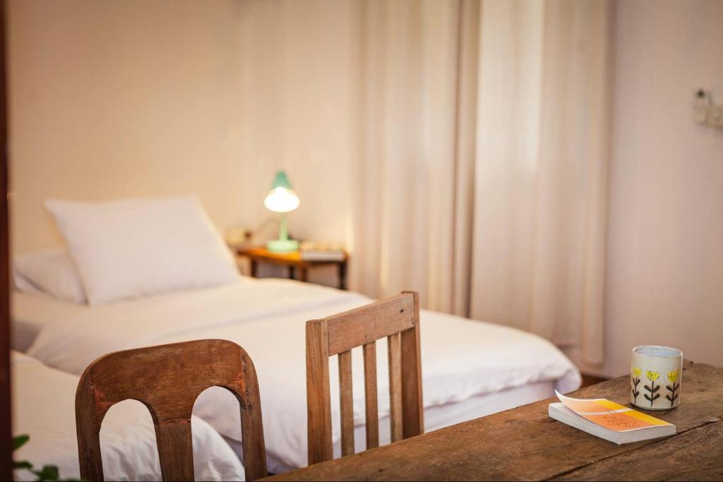 A compact work table and chairs positioned beside a double bed.