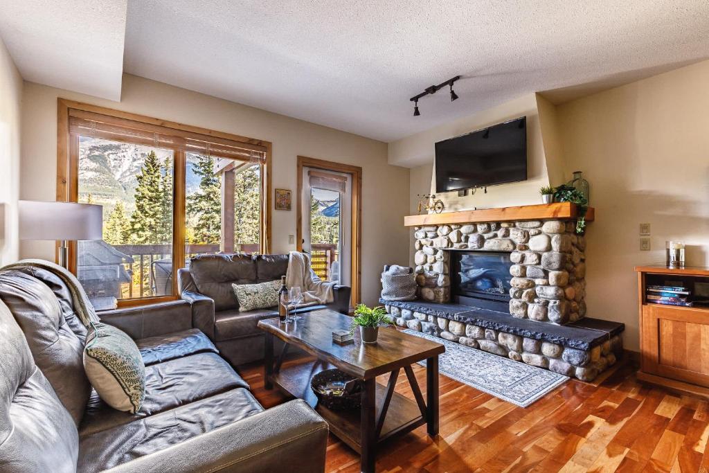 a living room with a couch and a fireplace at Creekside at Rundle Cliffs Lodge in Canmore