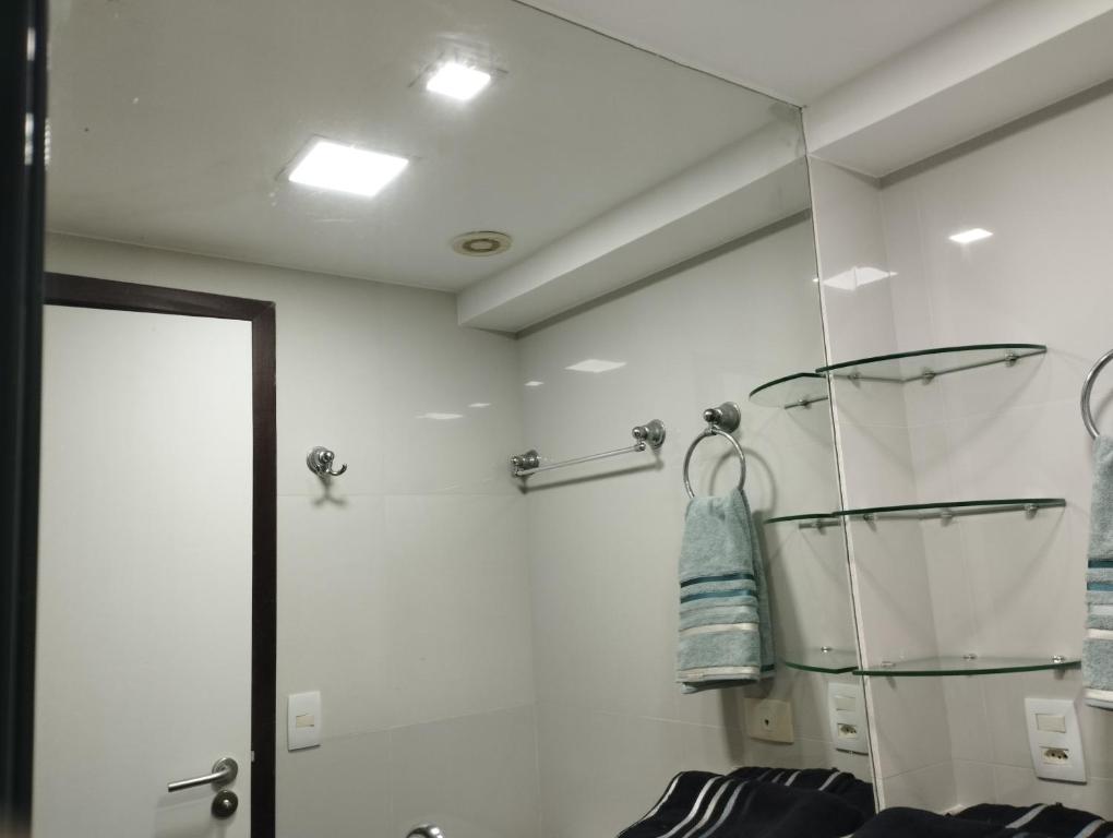 a bathroom with a glass shelf and a shower at Beach Class Executive Flat na Beira Mar de Boa Viagem in Recife