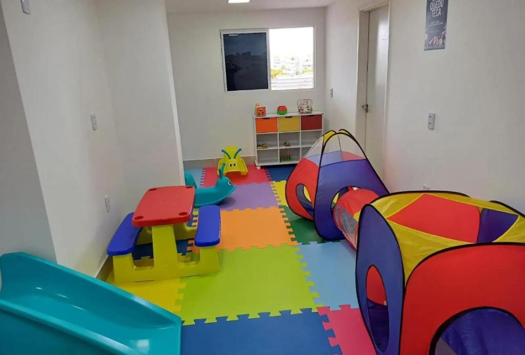 una stanza per bambini con una sala giochi con un pavimento colorato di Porto de Galinhas - Aline Duque Residence, Flat 205 a Porto De Galinhas