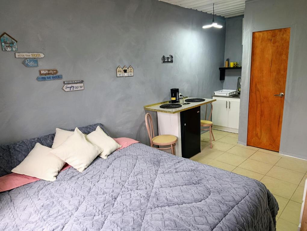 Un dormitorio con una cama y un escritorio y una cocina. en Habitación Studio con baño privado, en Iquique