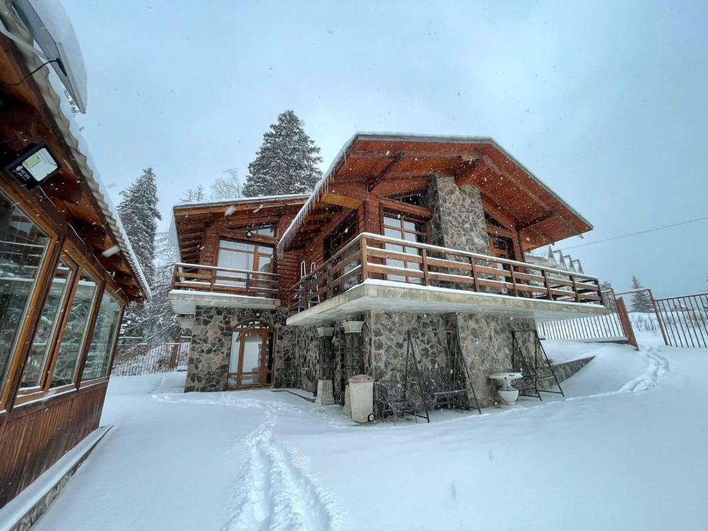 a log cabin in the snow in front at Villa Fox Bakuriani in Bakuriani
