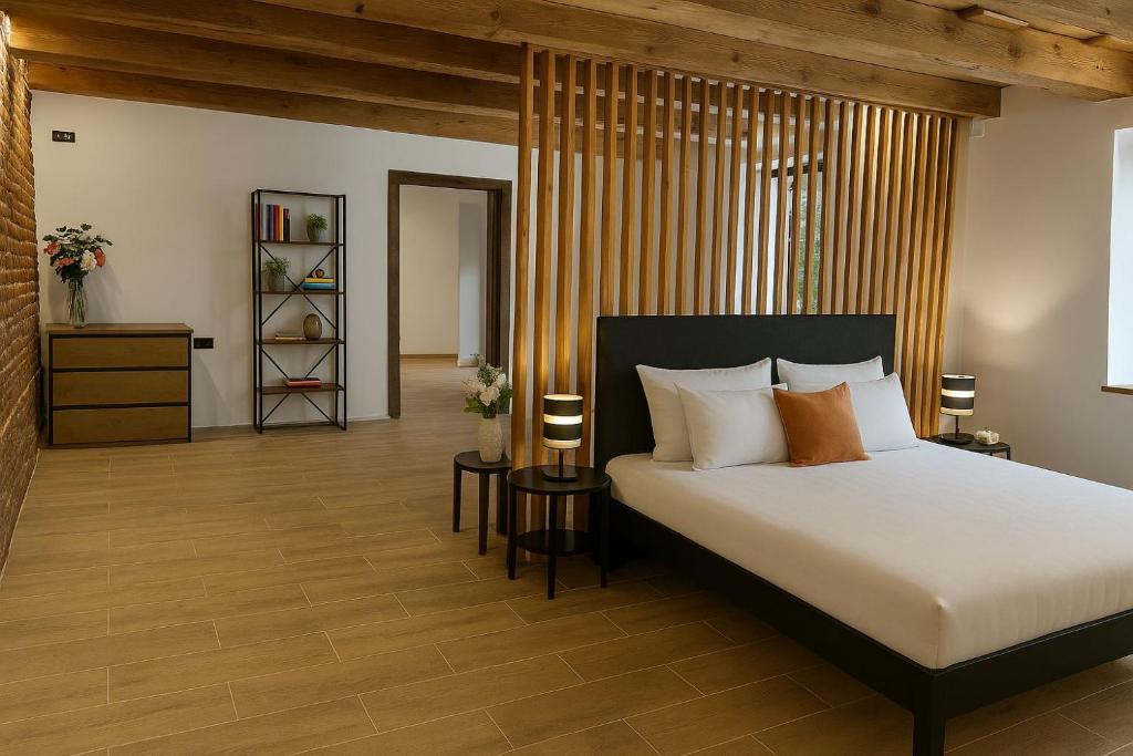 a bedroom with a bed with white sheets and orange pillows at ALBERT RESIDENCE Brasov in Braşov