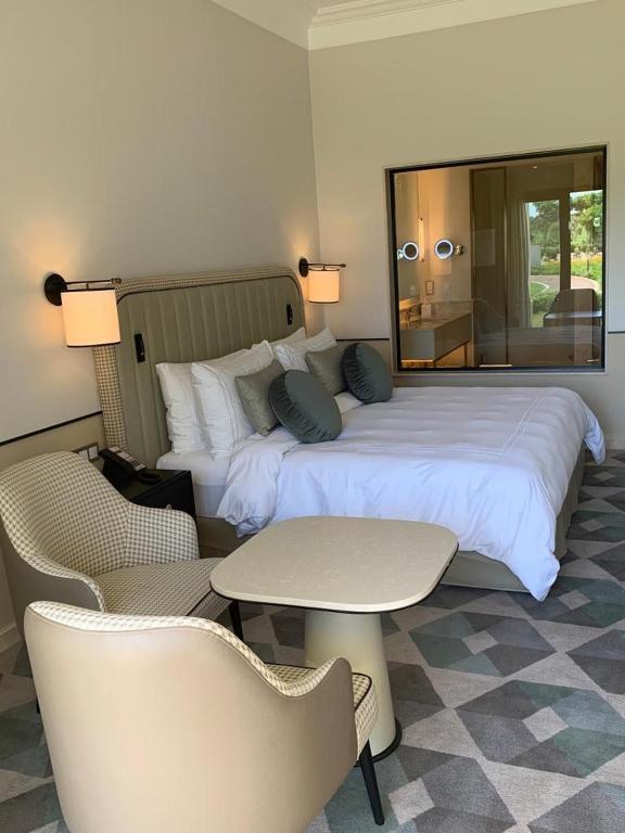 een hotelkamer met een bed, een tafel en stoelen bij Apartment at Adress Golf in El Alamein