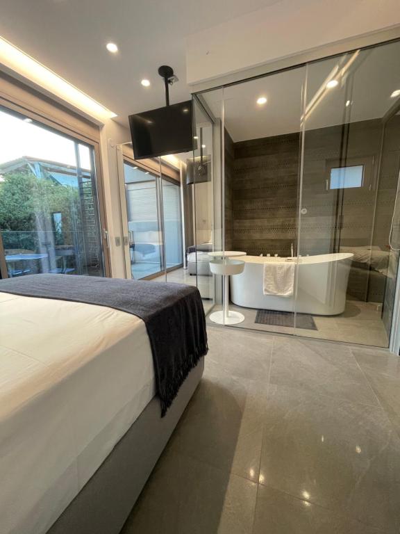 a bedroom with a tub and a bed and a bath room at SeaNest Bali in Bali