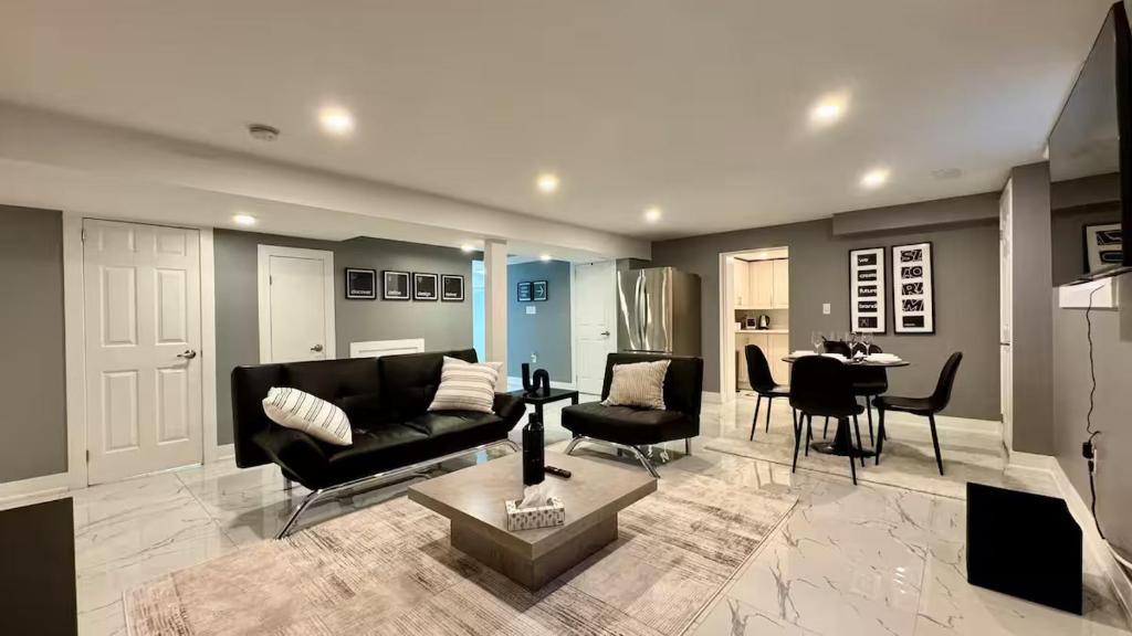 un salon avec un canapé noir et une table dans l'établissement Spacious and Luxurious 2BR Suite with Huge Windows, à Mississauga