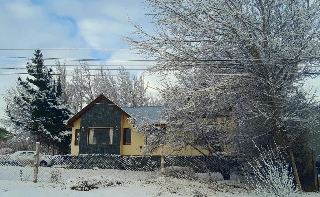 una casa gialla con neve per terra di Casa del Pino a El Calafate