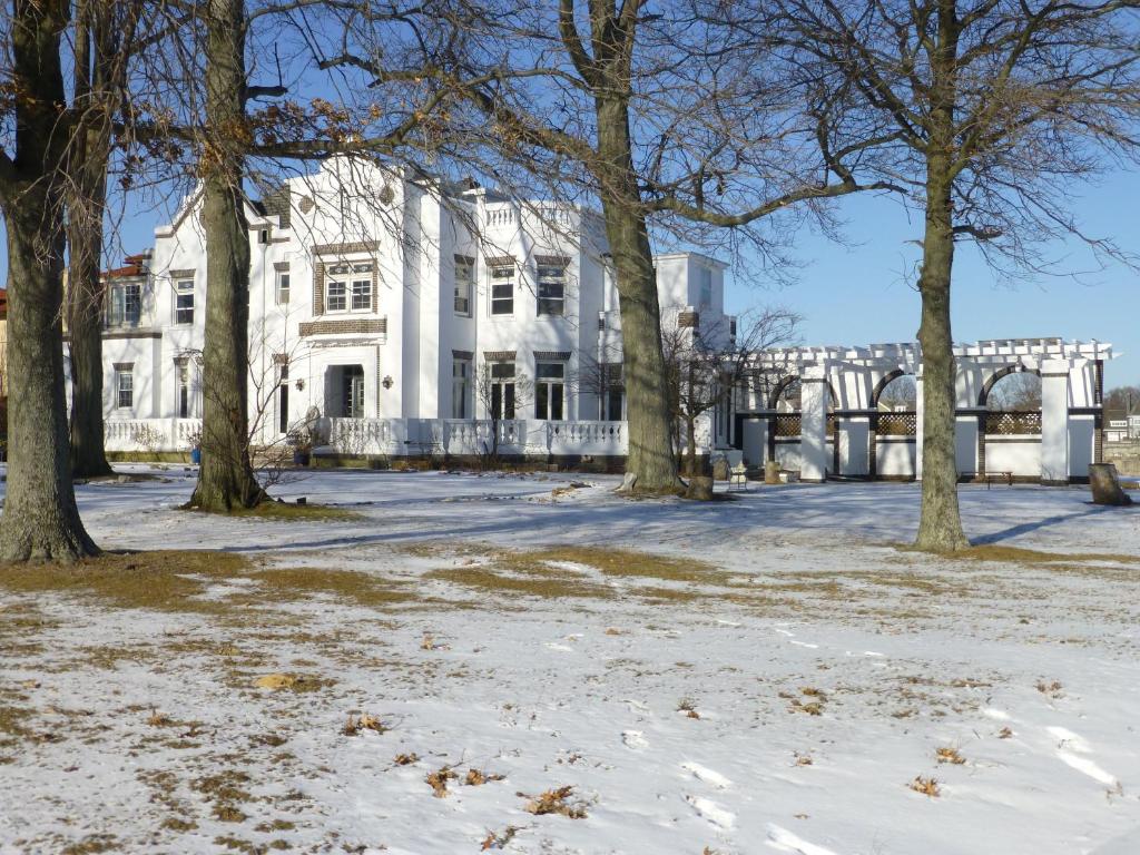 una casa bianca con alberi nella neve di Waterfront Retreat Center a New Rochelle