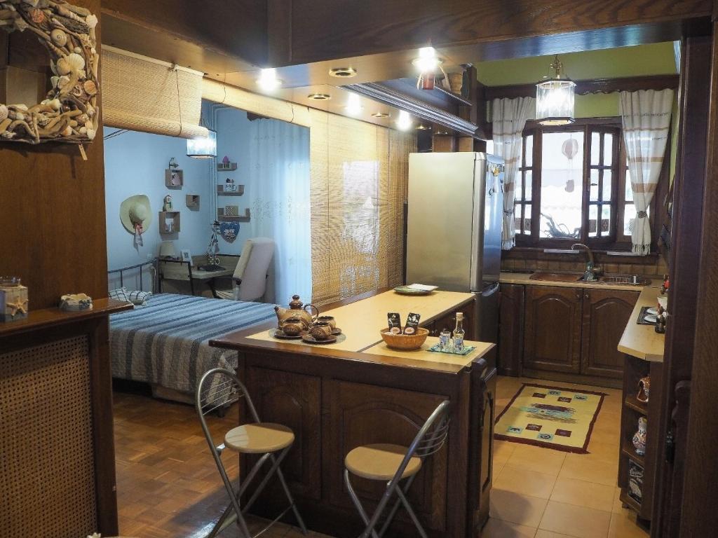 Habitación con cama y cocina con sillas. en Το σπίτι της Ολίβιας, en Volos