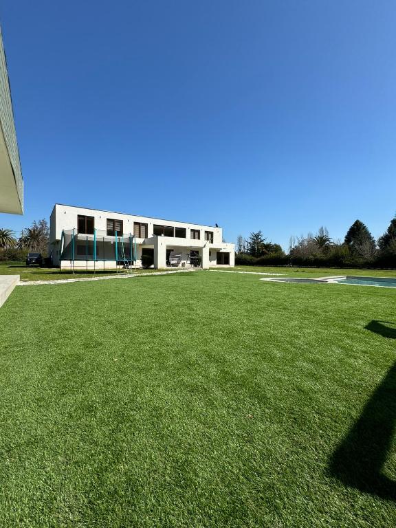 a large grass field with a building in the background at casa mediterranea in Calera de Tango
