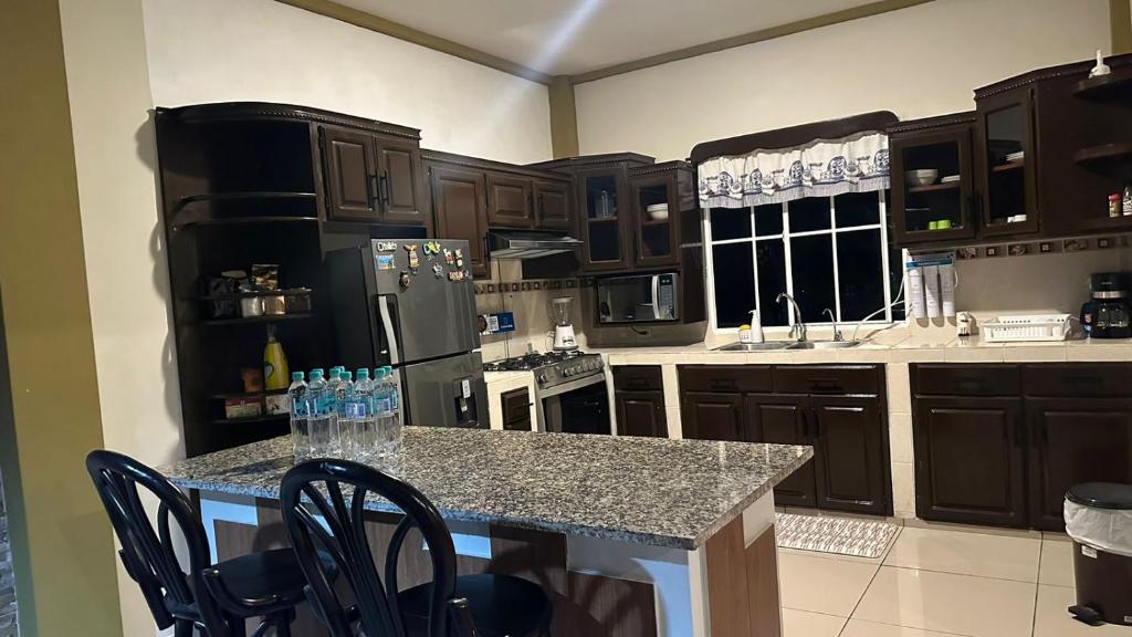 una cucina con armadi neri e bancone con sedie di La Casa de Sonya a Concepción de Ataco